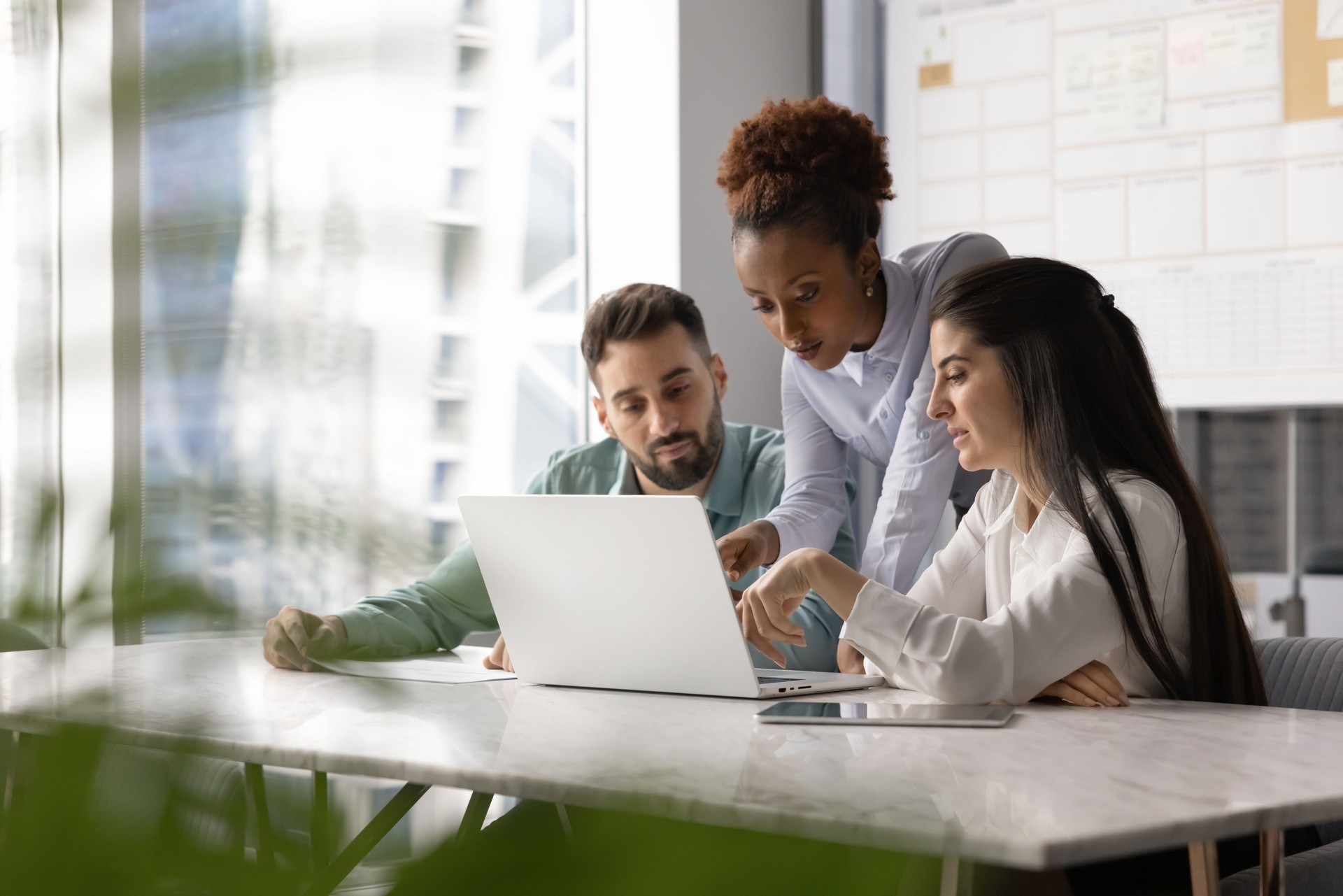 Multiethnic group of office colleagues discussing Internet marketing strategy